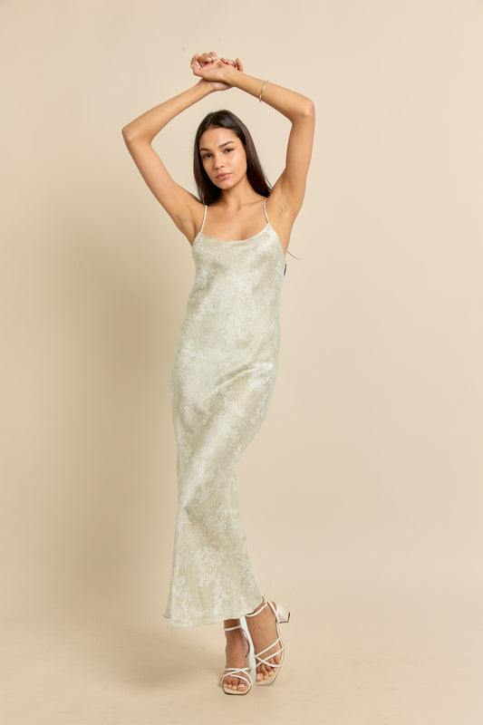 Woman wearing 90's silk slip dress in beige with white print.