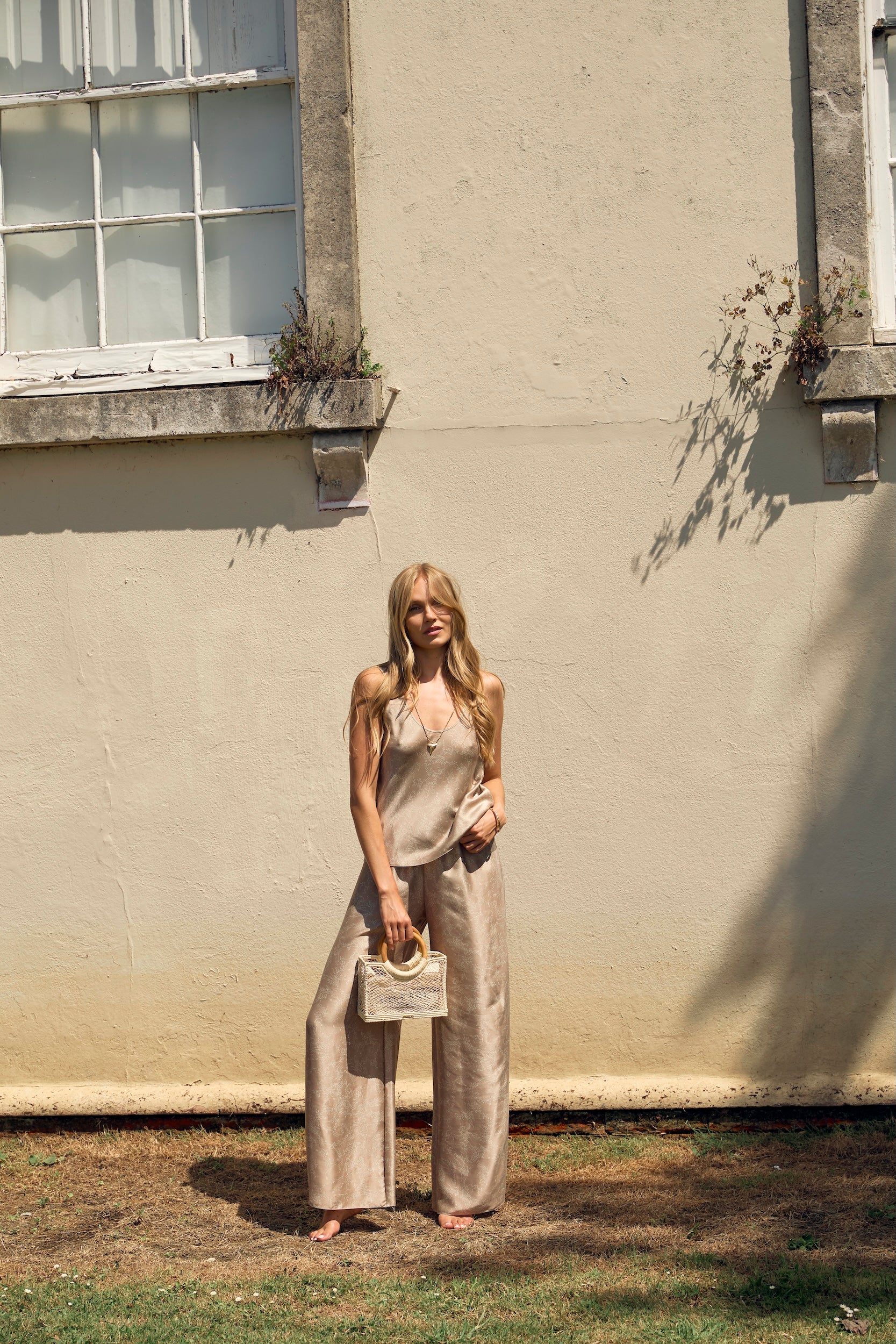 Woman wearing beige silk top and silk trousers coord for a day in the city