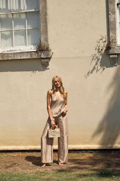 Woman wearing beige silk top and silk trousers coord for a day in the city