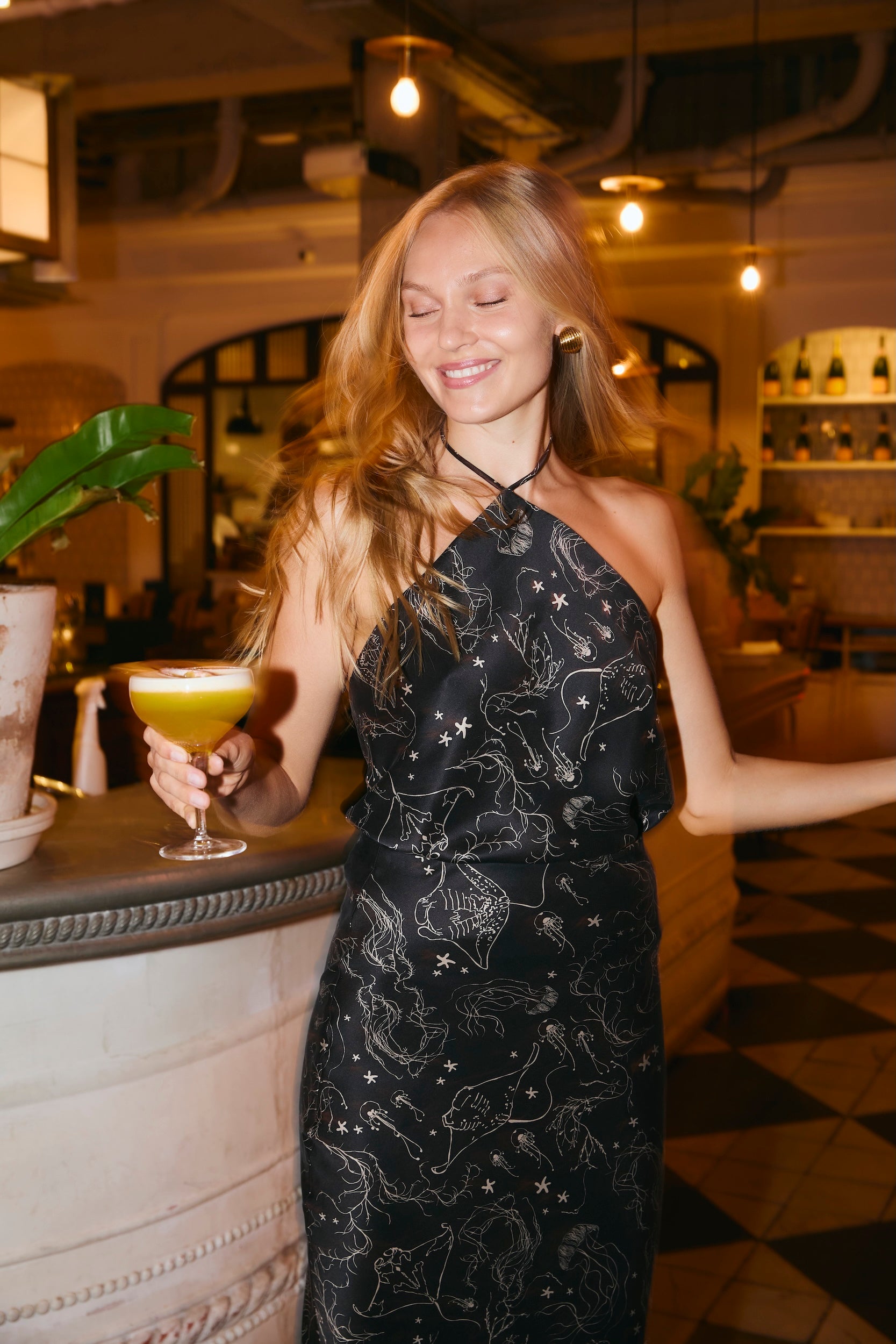 Woman wearing a silk black top dancing at a party