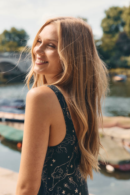 Woman wearing a black silk slip dress with a sea inspired, hand-drawn, print.