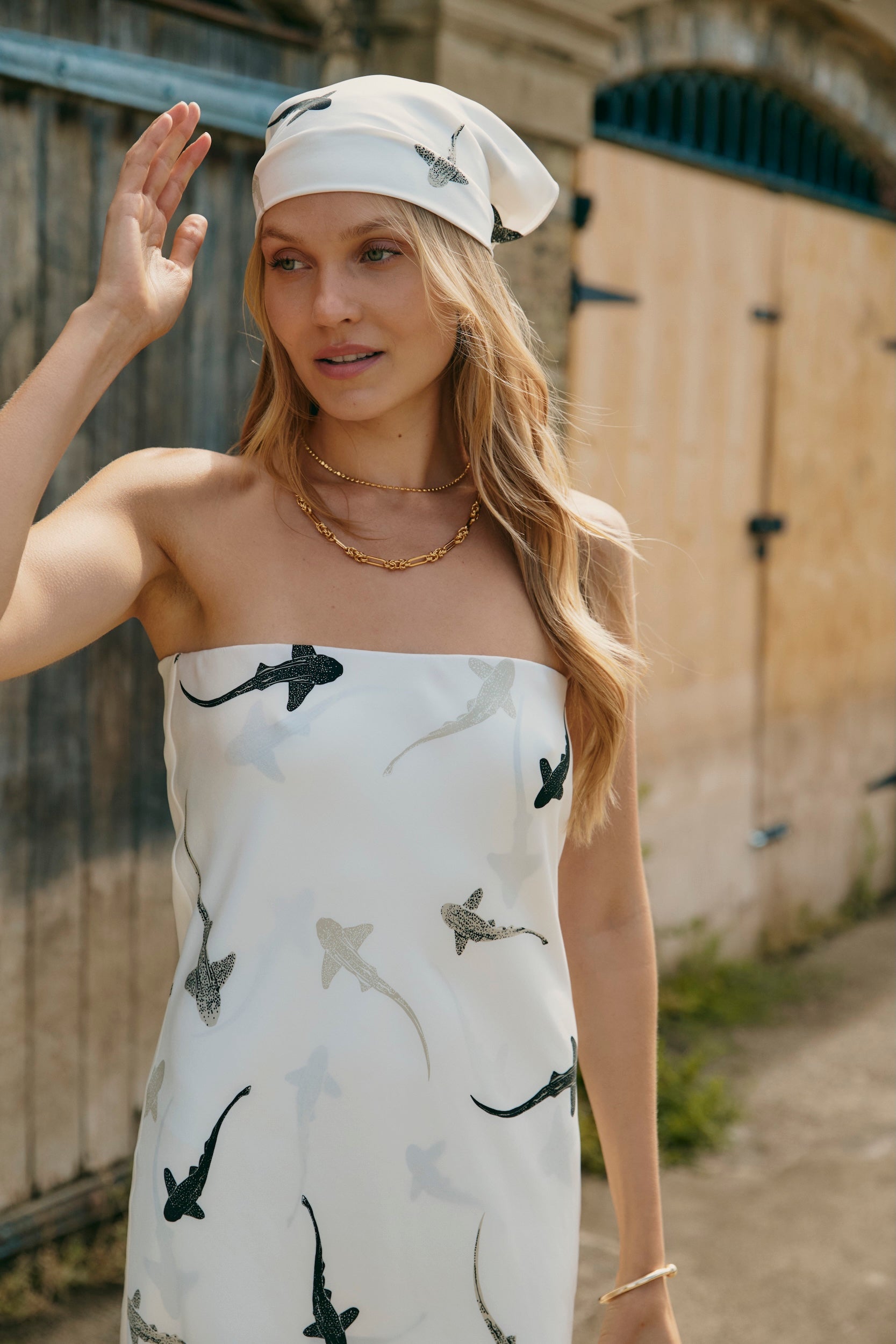 Woman wearing strapless bandeau silk slip dress with silk head scarf