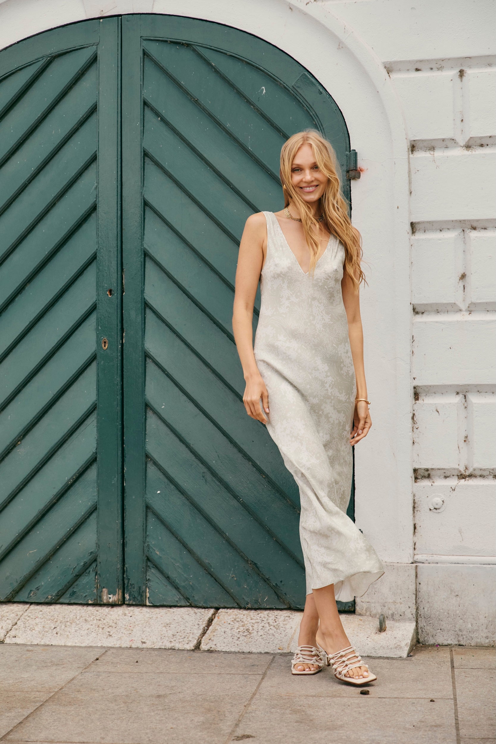 Woman in a light coloured silk slip dress on vacation