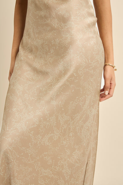 Woman wearing gold and beige silk slip dress, bias cut for a flattering drape. 